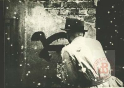 1941–1944, Warszawa.  Malowanie żółwia będącego odzwierciedleniem hasła Walki Cywilnej "pracuj Polaku powoli" przez członka Organizacji Małego Sabotażu "Wawer". Organizacja ta skupiała harcerzy i miała na celu uświadomienie ludności cywilnej o istnieniu i działalności konspiracji.